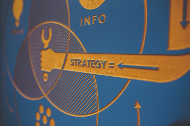 Chatbot trends image: wooden blue board "strategy," with arrow pointing toward it. 