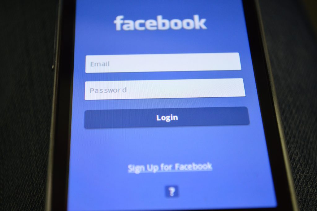 Facebook Login Screen with username and password on smartphone. Chatbots on website considerations 